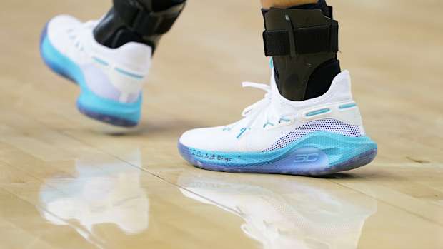 View of white and blue Under Amour shoes.
